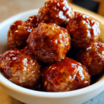 Glossy BBQ meatballs in a bowl, the ultimate 3-ingredient crockpot appetizer.