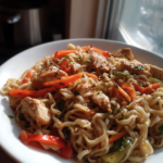 Savory garlic chicken lo mein with stir-fried vegetables, chicken, and sesame seeds.