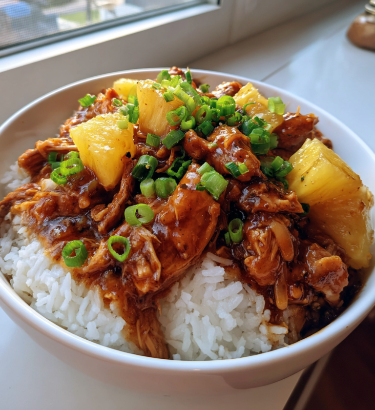 Sweet Hawaiian Crockpot Chicken served over white rice with pineapple and green onions.