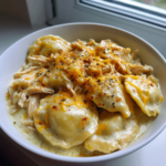 A bowl of creamy Crock Pot chicken pierogi stew topped with melted cheese and spices.