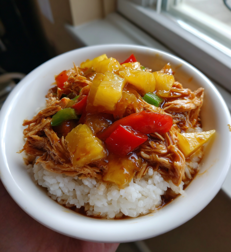 Sweet Hawaiian crockpot chicken with pineapple and bell peppers served over white rice.