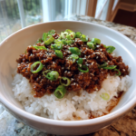 Savory Korean ground beef bowl served over white rice with green onions and sesame seeds.